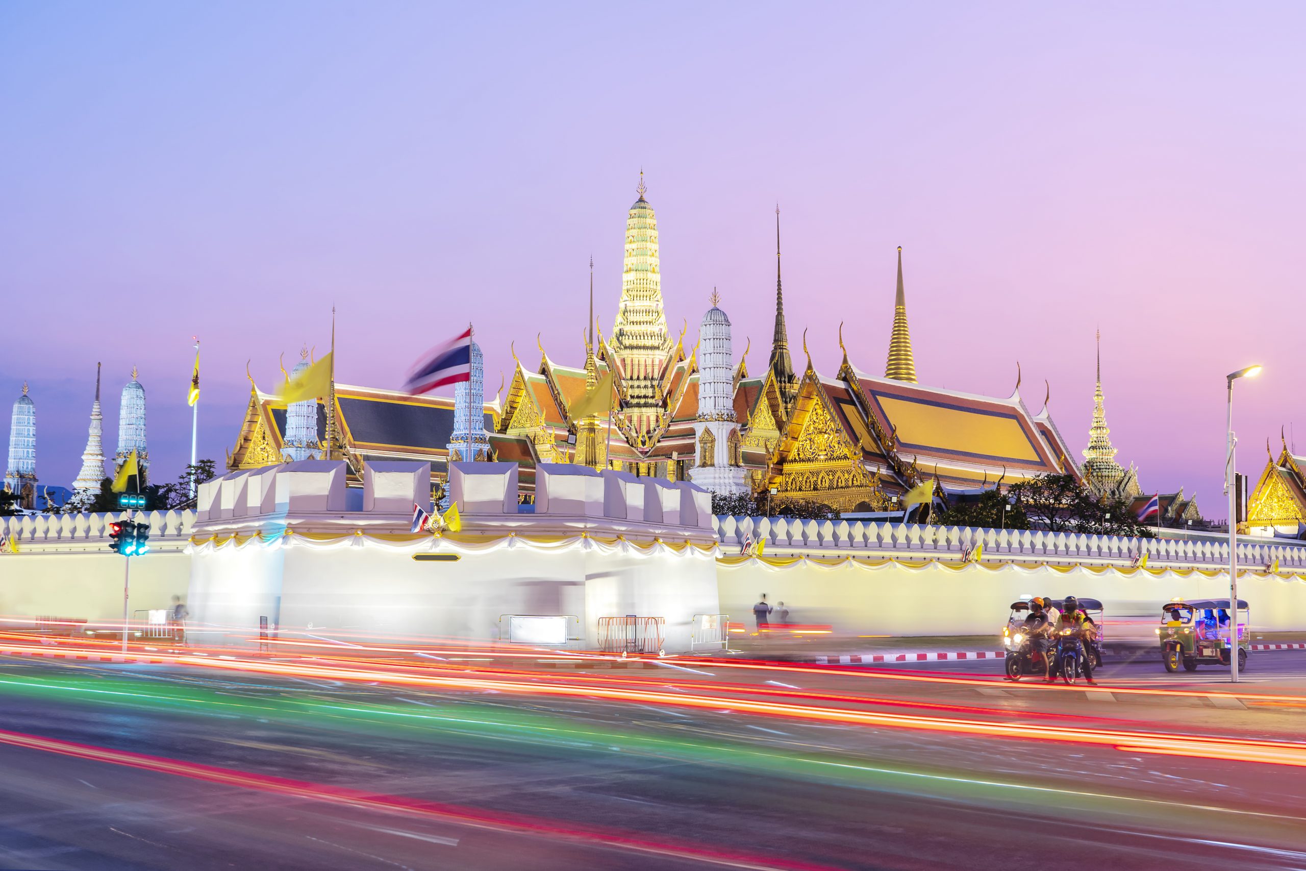 Grand palace and Wat phra keaw at sunset bangkok, Thailand. The traffic beam is a beautiful color for the foreground.